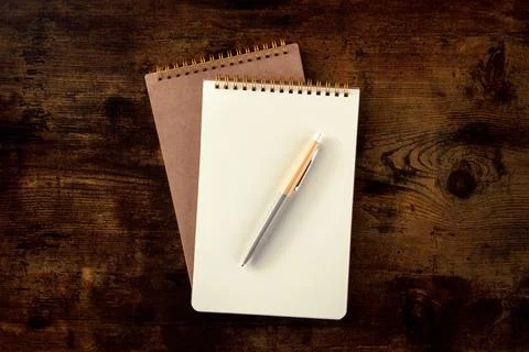 Notebook mockup with a pen, overhead flat lay shot on a wooden desk Stock Photos