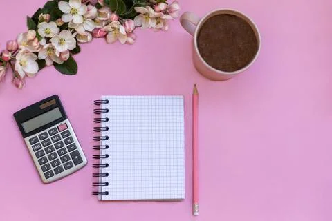 A notebook for notes lies on a pink background, next to pen, calculator, coffee Stock Photos