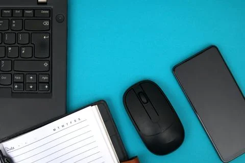 The notebook is open on the laptop next to the smartphone Stock Photos