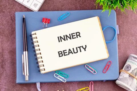 A notebook open to the page displaying the words inner beauty is surrounded.. Stock Photos
