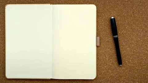 Notebook opening journal turning pages with pen overhead top down stop motion Stock Footage 143502581
