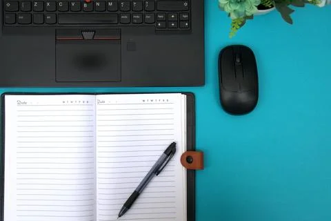 The notebook opens on top of the laptop Stock Photos