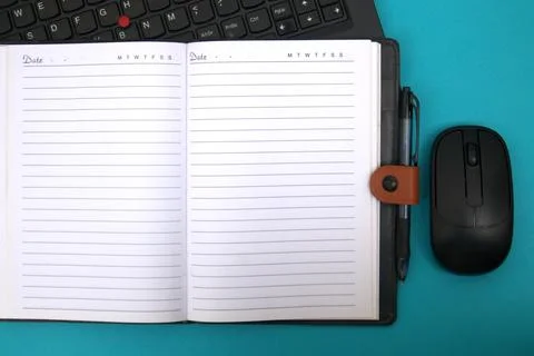 The notebook opens on top of the laptop Stock Photos