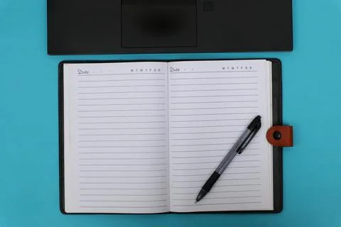 The notebook opens on top of the laptop Stock Photos