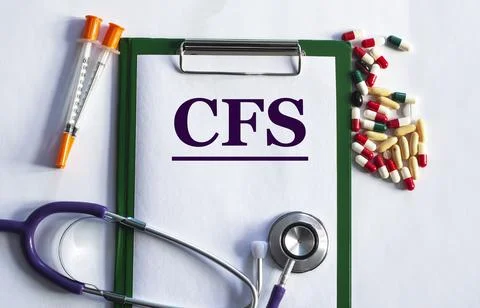 Notebook pade with acronym CFS on a table with a stethoscope and pills Stock Photos