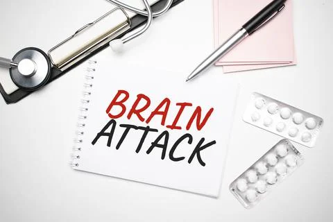 Notebook page with text Heart Attack, on a table with a stethoscope and pen,  Stock Photos