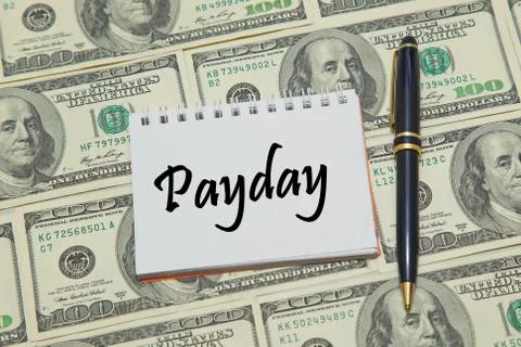 Notebook page with text PAYDAY on dollar background Stock Photos