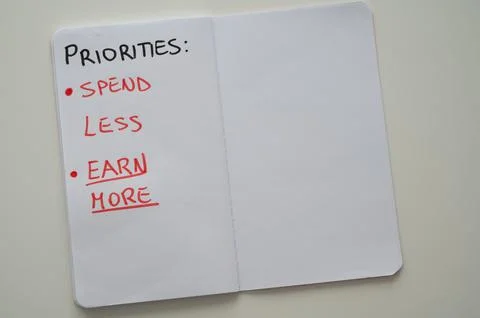 Notebook page, with text "priorities: spend less, earn more" Stock Photos