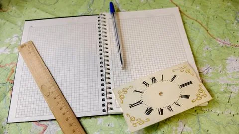 Notebook with pen and clock in the background Stockfoto's