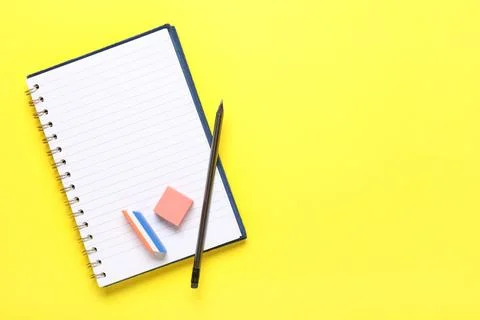 Notebook with pen and different erasers on yellow background Stock Photos