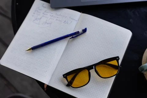 Notebook, pen and glasses on table 스톡 사진