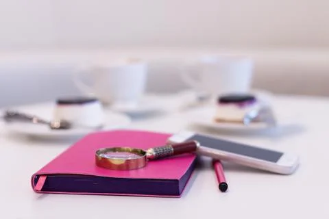 A Notebook with a Pen on the Background of a Pair of Coffee Stock Photos