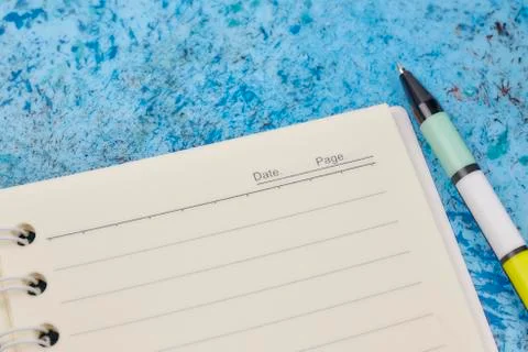 Notebook, pen, on blue abstract background. horizontal view from above. white Stock Photos
