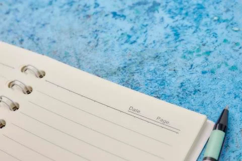 Notebook, pen, on blue abstract background. horizontal view from above. white Stock Photos
