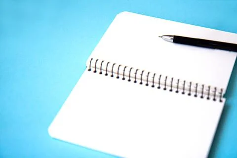 Notebook with pen on blue background Stock Photos