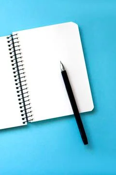 Notebook with pen on blue background Stock Photos