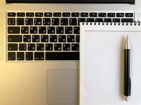 Notebook with pen on laptop keyboard Stock Photos