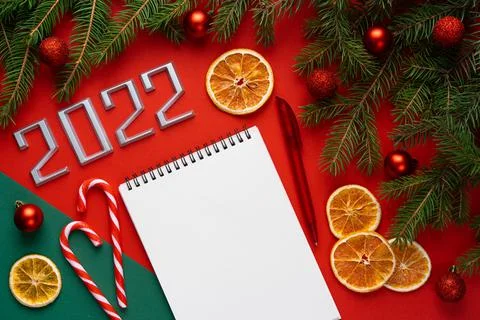 A notebook with a pen on a red background, a Christmas background with fir Foto stock