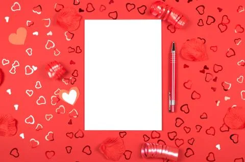 Notebook with pen on red background with heart-shaped confetti. Stock Photos
