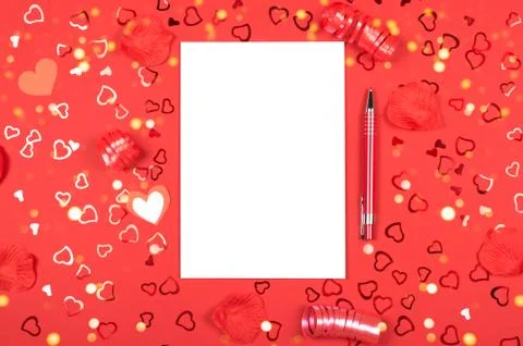 Notebook with pen on red background with heart-shaped confetti. Stock Photos