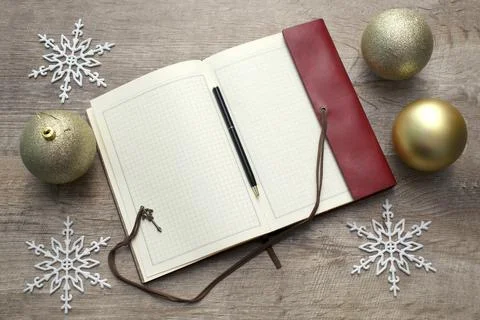 Notebook with pen on table. New year's decorations and golden christmas balls Stock-Fotos