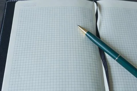 Notebook with pen on white background. Close-up view. Stock Photos