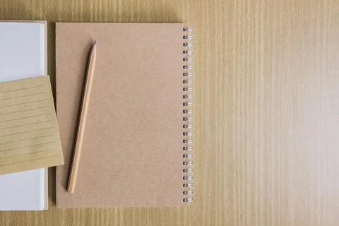 Notebook with pencil and note over the wooden table. Stock Photos