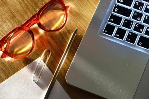 Notebook, pencil, glasses and computer in red and blue light. Stock Photos