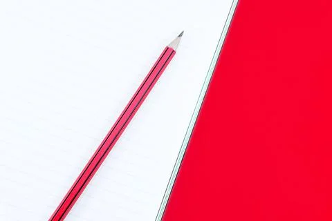 Notebook with pencil on red background Foto stock
