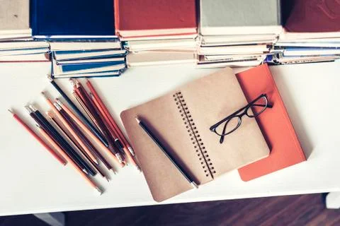 Notebook, pencils, glasses and stack of books, school background for educatio Stock Photos