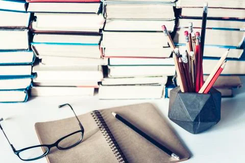 Notebook, pencils, glasses and stack of books, school background for educatio Stock Photos