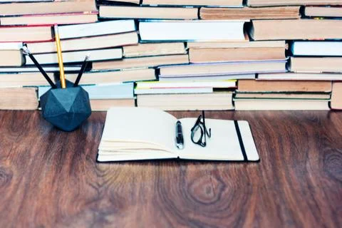 Notebook, pencils, glasses and stack of books, school background for educatio Stock Photos