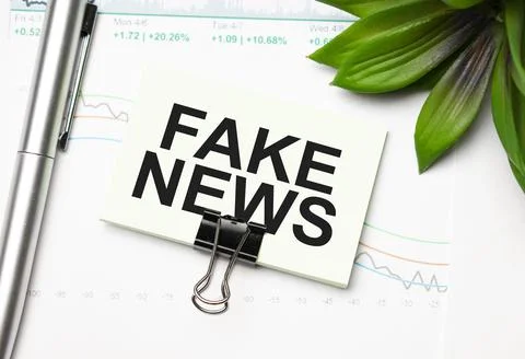 Notebook with pencils, glasses on the graph background, with text FAKE NEWS Stock Photos