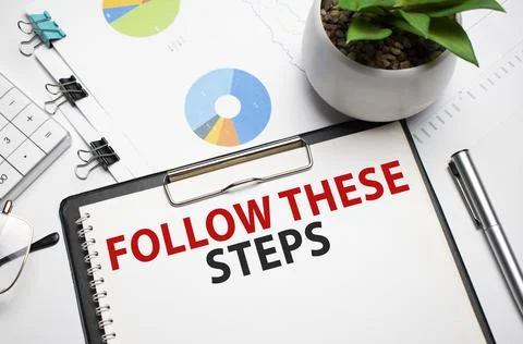 Notebook with pencils, glasses on the graph background, with text Follow thes Stock-Fotos