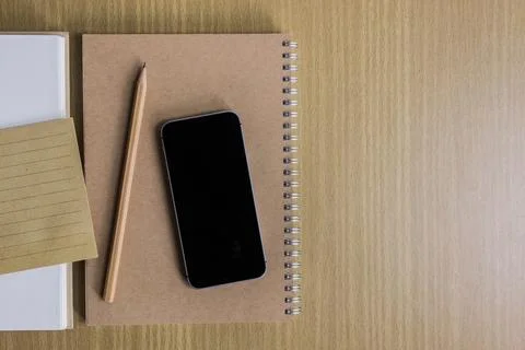Notebook, phone, pencil and note on a wooden table. Foto stock