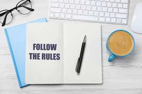 Notebook with phrase Follow The Rules, pen, computer keyboard and cup of co.. Stock Photos