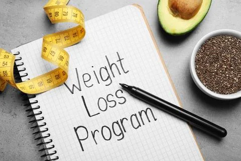 Notebook with phrase Weight Loss Program, measuring tape, chia seeds and av.. 스톡 사진