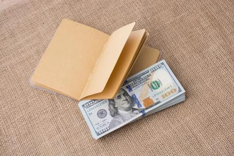 Notebook placed beside US dollar banknotes Stock Photos