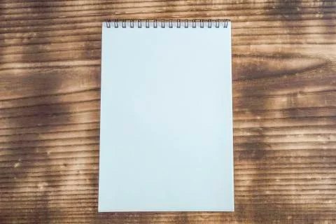 A notebook placed on a wooden table Stock Photos