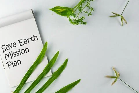 Notebook with 'Save Earth Mission Plan' Printed Alongside Green Plant Element Stock Photos