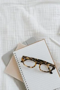 Notebook sheets, pen, glasses on white background. Work at home flat lay, top Stock Photos