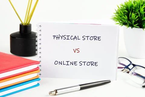 A notebook shows the words physical store and online store side by side. Pens Stock Photos