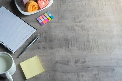 Notebook, smartphone, jam roll, cup of milk, pen on wooden, paper note Busine Stock Photos