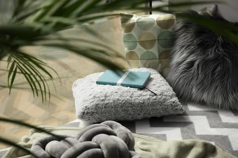 Notebook, soft pillows and plaids on window sill in room. Cozy place to relax Stock Photos