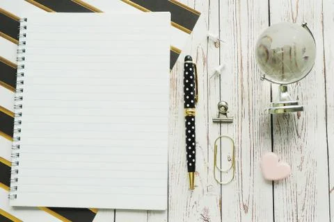 Notebook on a spring, pen, carnations, paper clips and a glass globe on a str Stock Photos