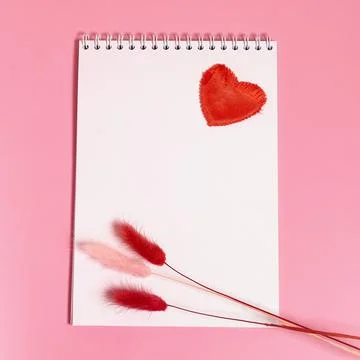 A notebook with a spring, a red textile heart and dried lagurus flowers Stock Photos