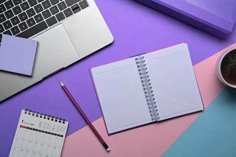 Notebook, sticky note, coffee cup and laptop computer on purple background. 写真素材