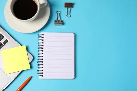 Notebook, sticky note, pen, binder clips, coffee and laptop on light blue b.. Stock Photos