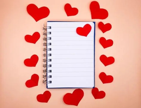 Notebook surrounded by red hearts on beige background, Valentine concept Stock Photos
