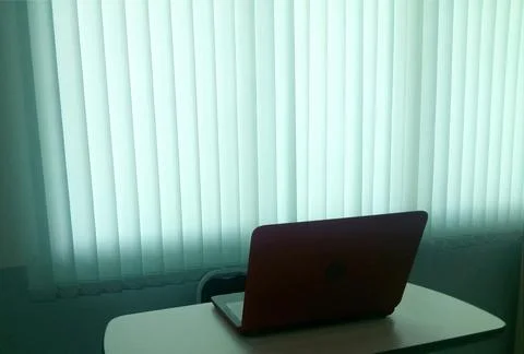 Notebook on table with blind light curtain Stock Photos